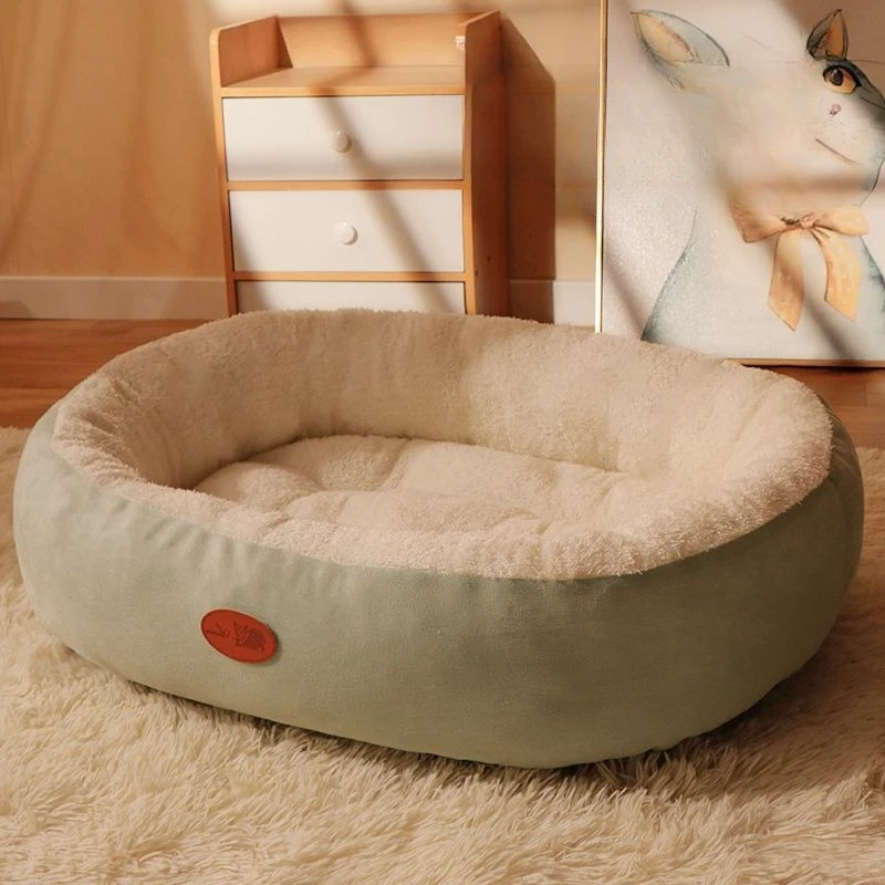 Panier rond en peluche beige à bord vert sauge sur un tapis à longs poils, devant une commode