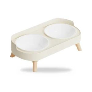 Gamelle double surélevée sur support en bois crème avec deux bols blancs, sur fond blanc