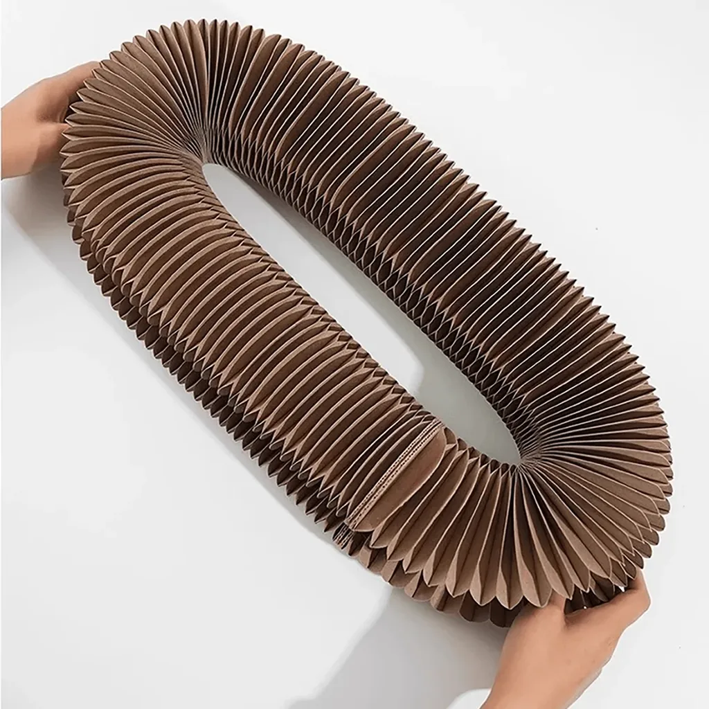Griffoir en carton accordéon déplié en grande boucle, tenu à deux mains sur un fond clair