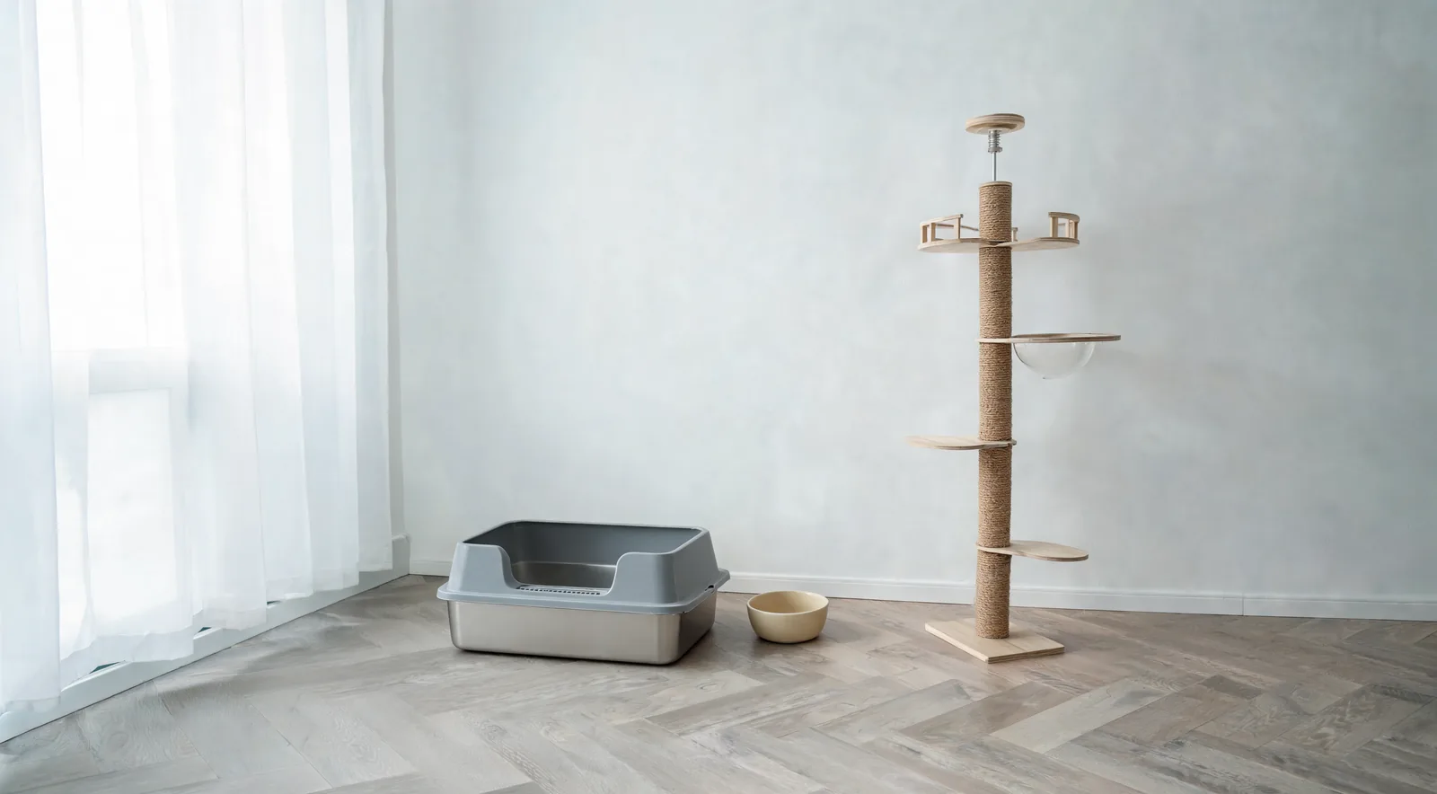 Kit d'arrivée pour chat dans un salon rangé : bac à litière inox avec couvercle, arbre à chat en sisal et gamelle crème